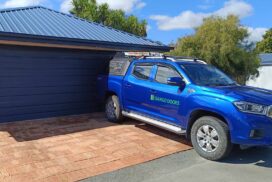 Professional technician performing maintenance on a residential garage door, checking and adjusting the door's components for smooth and reliable operation.