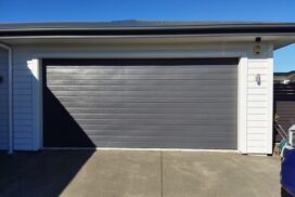 A technician repairing the weather strip on a garage door, ensuring a tight seal to prevent drafts and water from entering the garage.