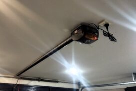 A technician syncing new remotes to a motorised garage door, ensuring proper functionality and remote control operation.